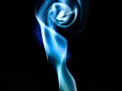 Incense smoke drifting in a dark yoga room.