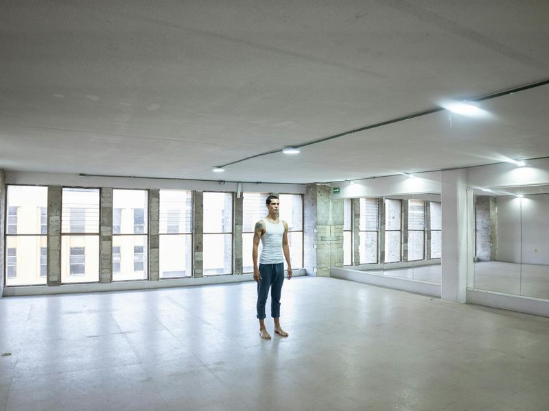 Large panoramic view of a minimalist yoga studio interior.
